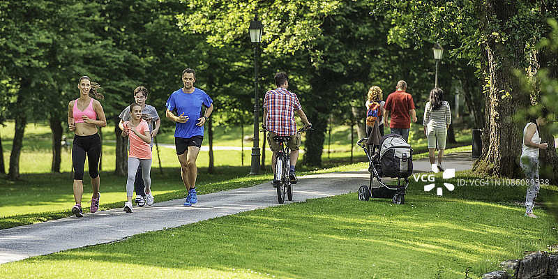 一家人在阳光明媚的日子里在公园慢跑图片素材