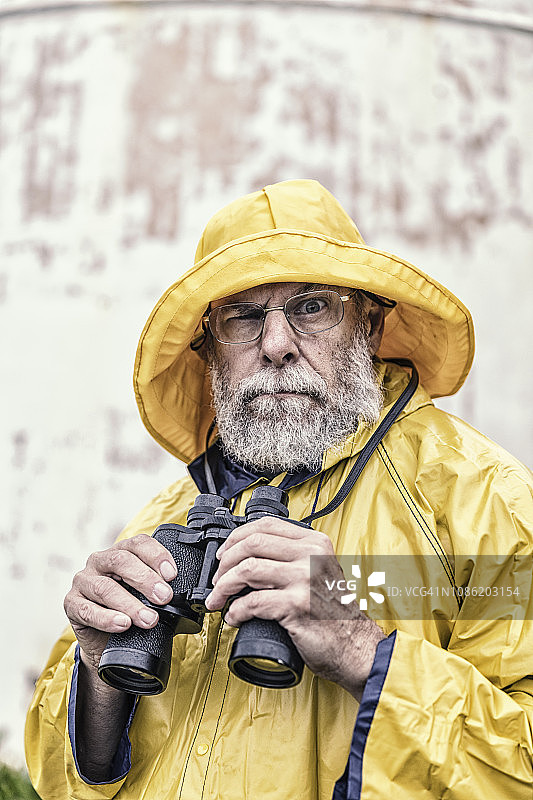 手持双筒望远镜看向镜头的幽默船长图片素材