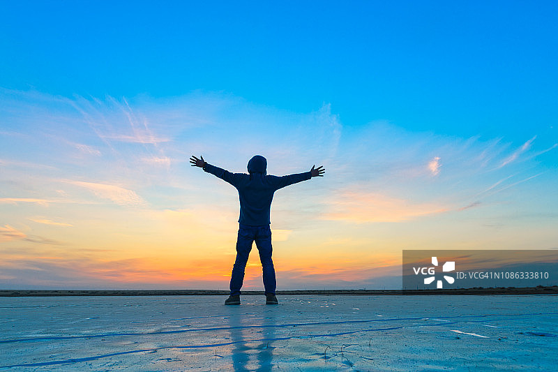 夕阳下站在冰面上的男人图片素材
