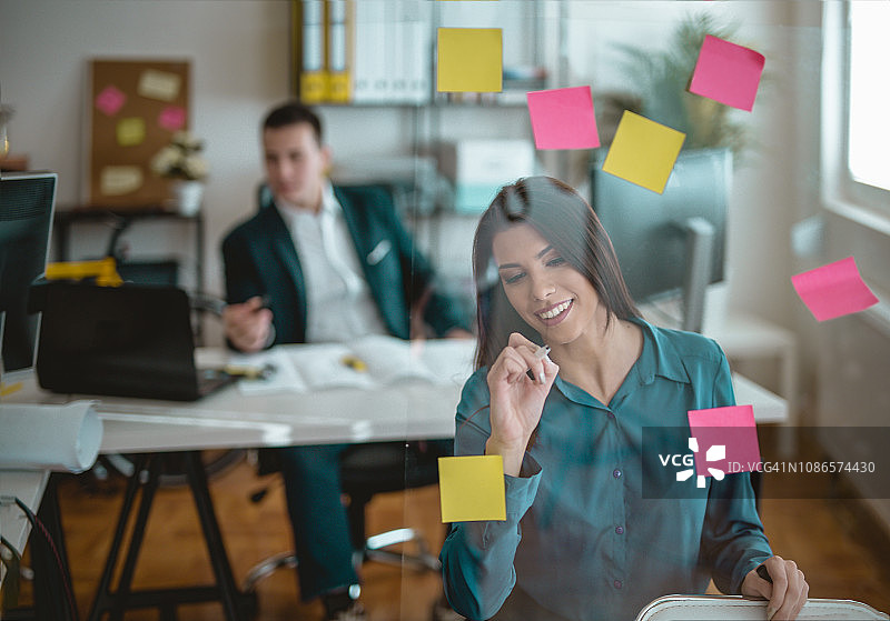 在透明白板上书写的漂亮女商人图片素材