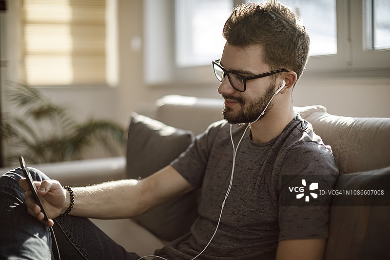 年轻男人在家使用社交媒体图片素材