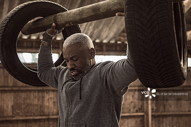 在废弃农场锻炼的中年黑人拳击手图片素材
