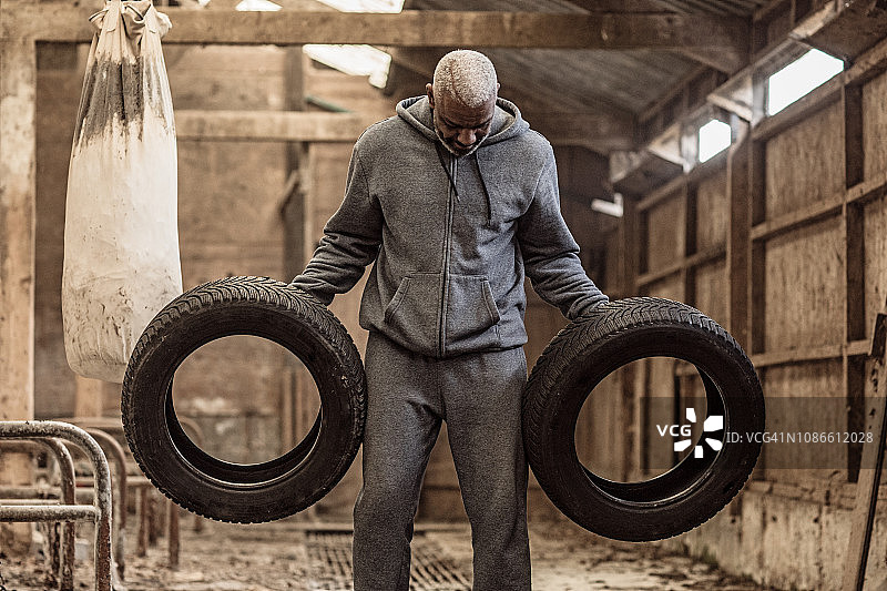 在废弃农场锻炼的中年黑人拳击手图片素材