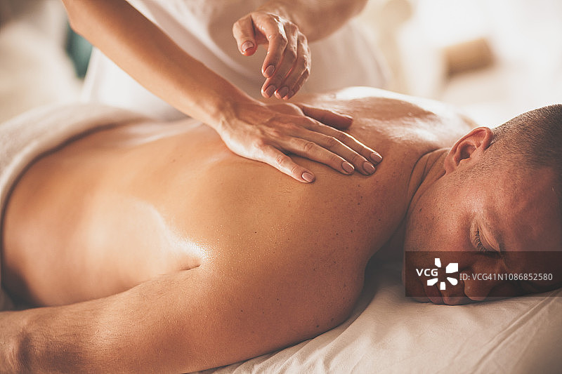 男人在水疗中心接受按摩治疗图片素材