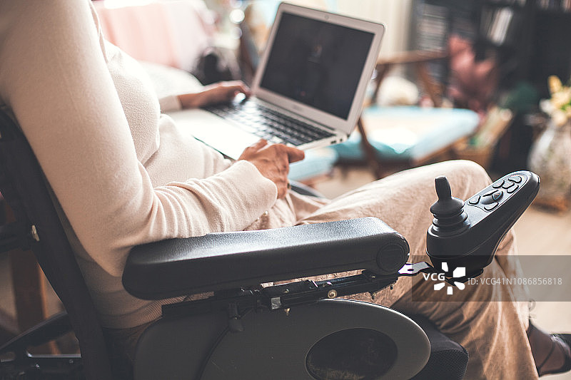 坐在轮椅上使用笔记本电脑的女人图片素材