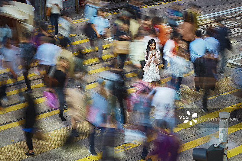 在人群中使用手机的女商人图片素材
