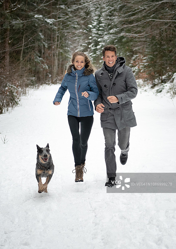 情侣在雪中奔跑图片素材