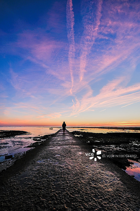 站在海边码头上的女子剪影，法国新阿基坦雷岛图片素材