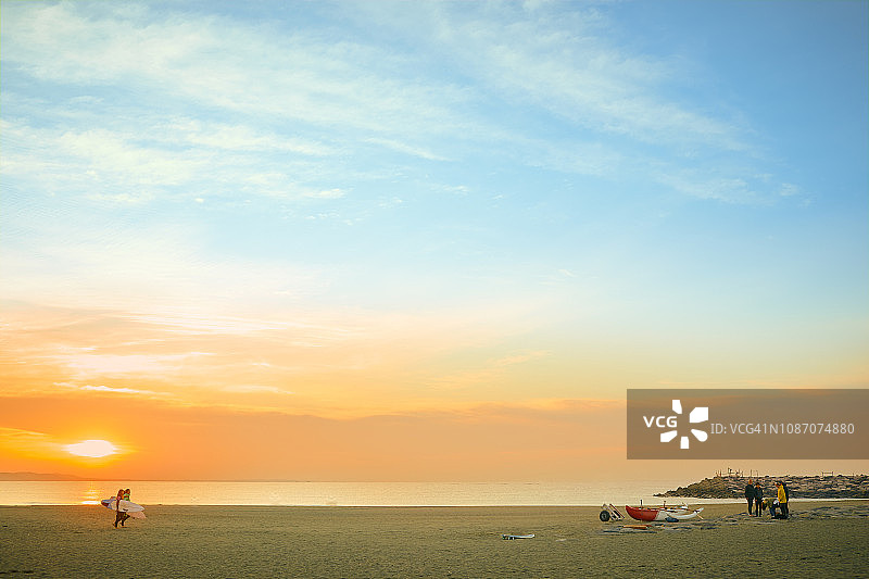 当地冲浪者和独木舟手在晨曦中相遇图片素材