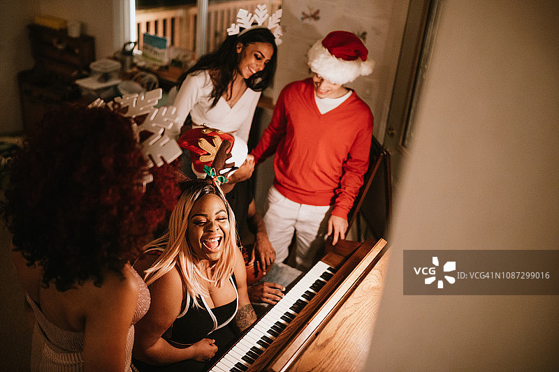 Z世代朋友在圣诞派对上弹钢琴唱歌图片素材