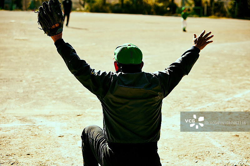 棒球教练做出“让我们团结一致”的手势，眺望远方图片素材