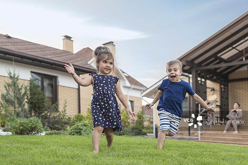 兄妹在后院草地上奔跑玩耍图片素材
