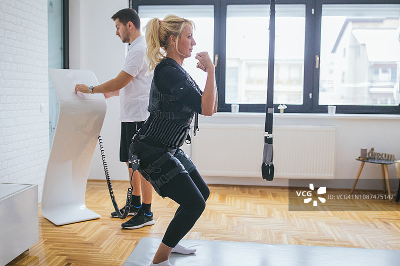 在私人教练指导下进行EMS训练的女人图片素材