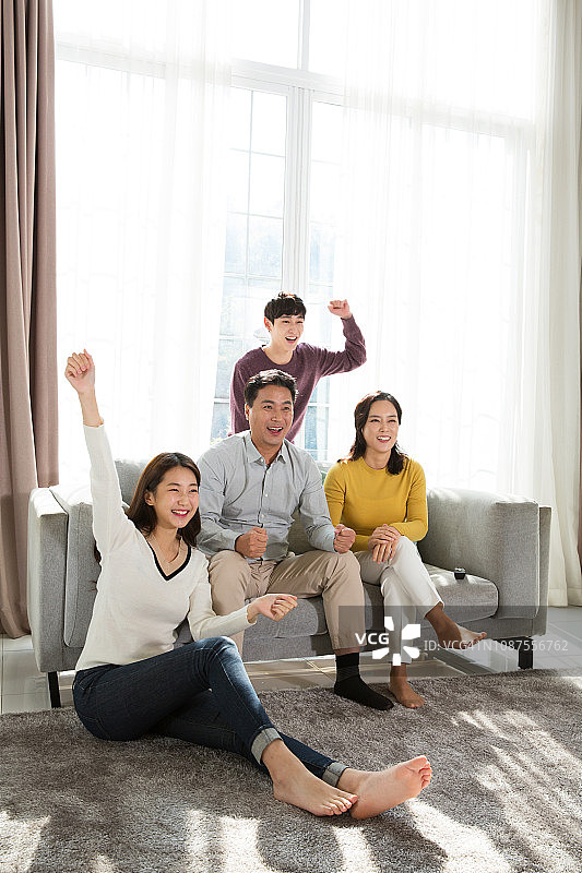 一家人一起欢呼雀跃地看电视图片素材