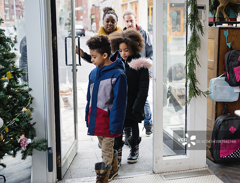 冬季城市街道上购物的混血家庭图片素材
