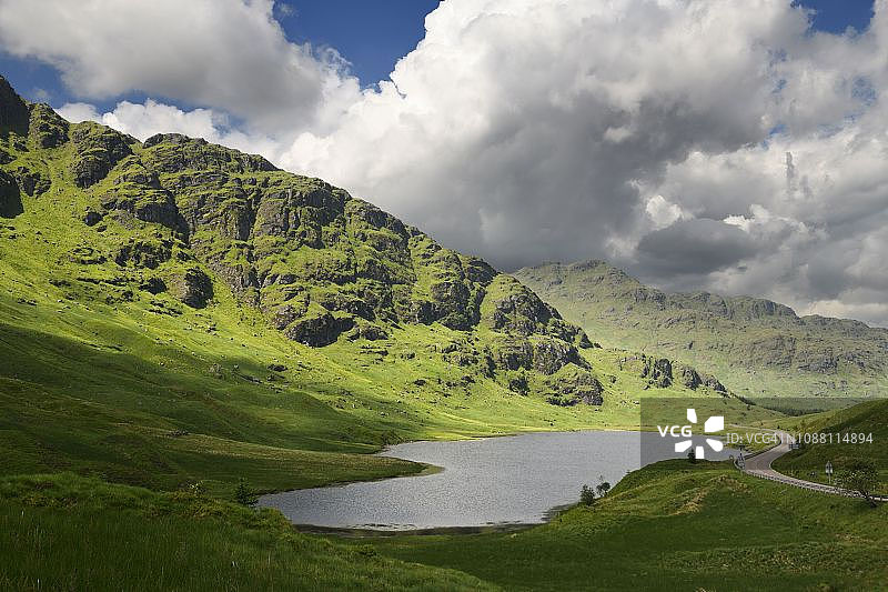 阳光下的阿罗卡阿尔卑斯山脉：洛凯恩山和宾尼安菲德勒山，以及休息和感谢纪念石，苏格兰洛奇瑞斯蒂尔图片素材