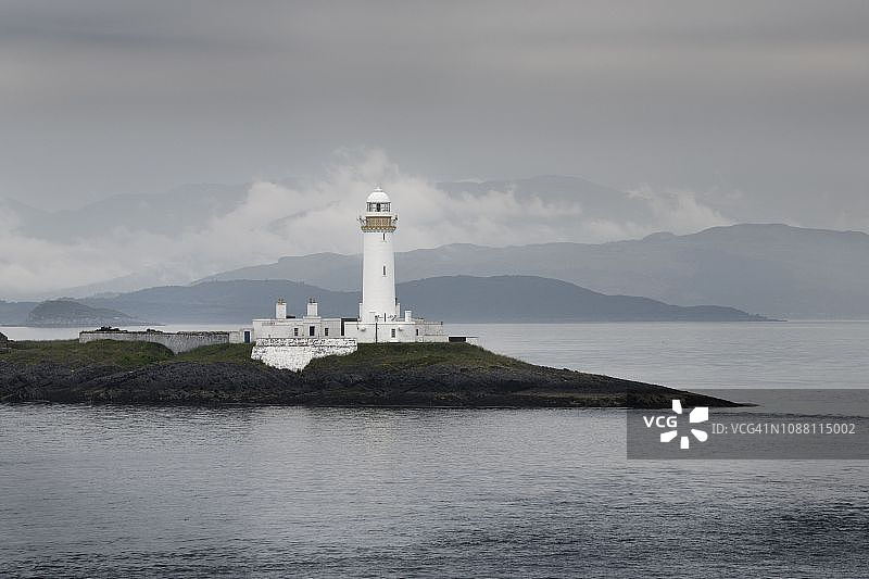 苏格兰利斯莫尔岛穆斯代尔小岛上的利斯莫尔灯塔，西海岸高地笼罩在雨雾中图片素材
