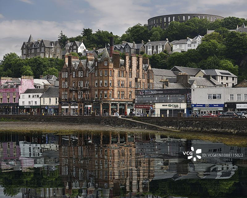 苏格兰奥班港口电池山上的历史建筑与麦凯格塔，水中倒影图片素材