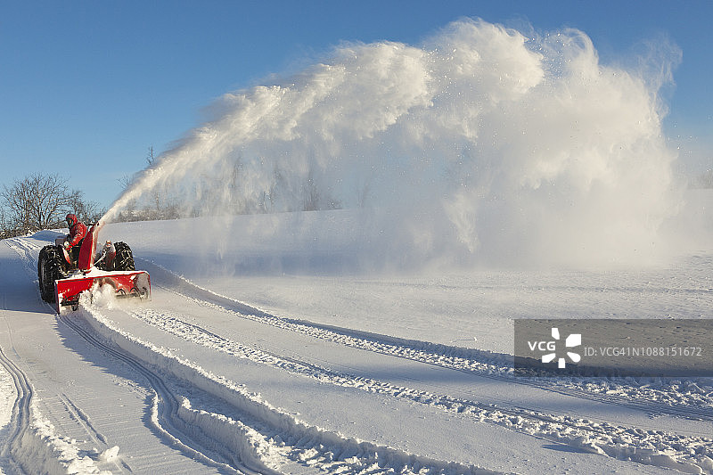 拖拉机和抛雪机在车道上清扫积雪图片素材