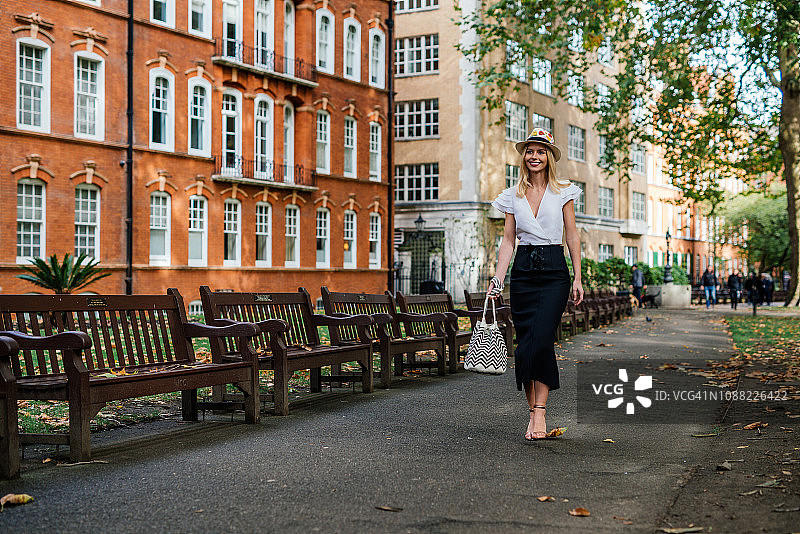 伦敦的时尚生活 - 阳光明媚的秋日戴现代帽子的金发女郎图片素材