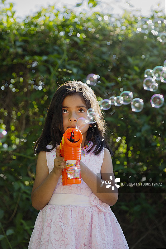 穿着太阳裙和泡泡机的女孩图片素材