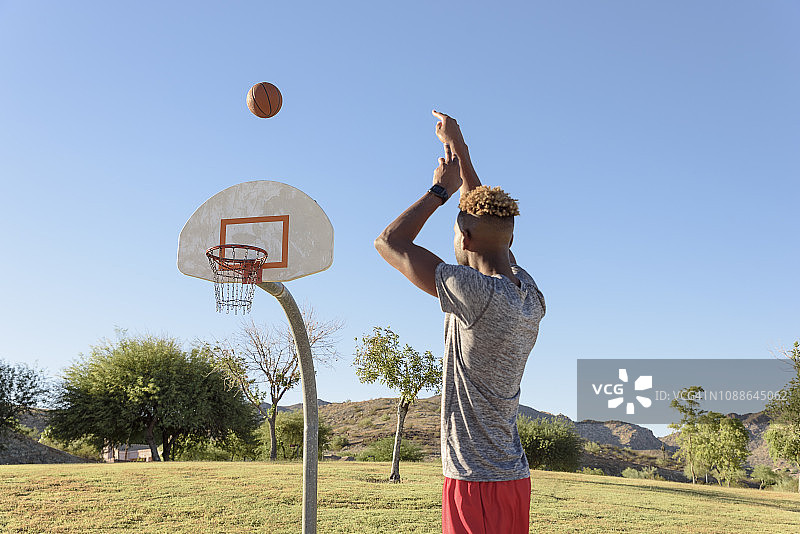 男子将篮球投向篮筐图片素材