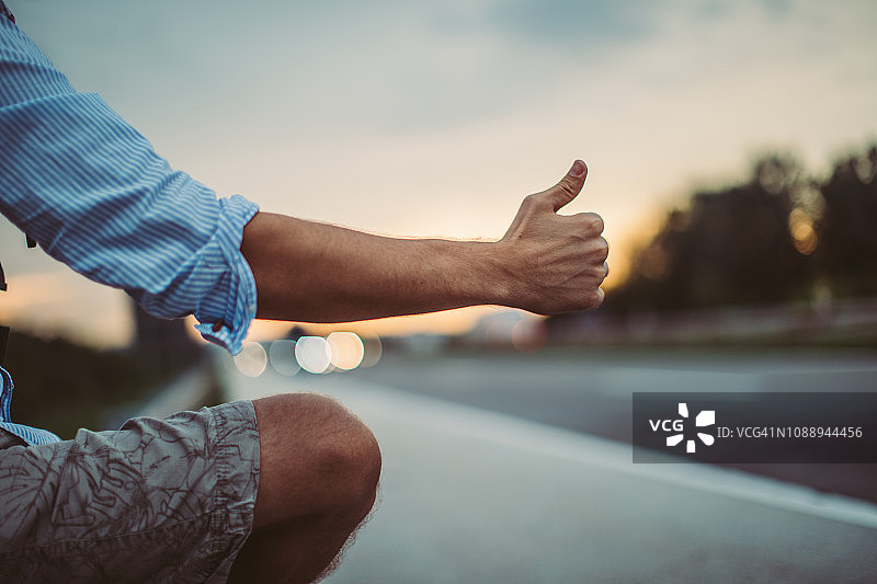 男子竖起大拇指搭便车图片素材