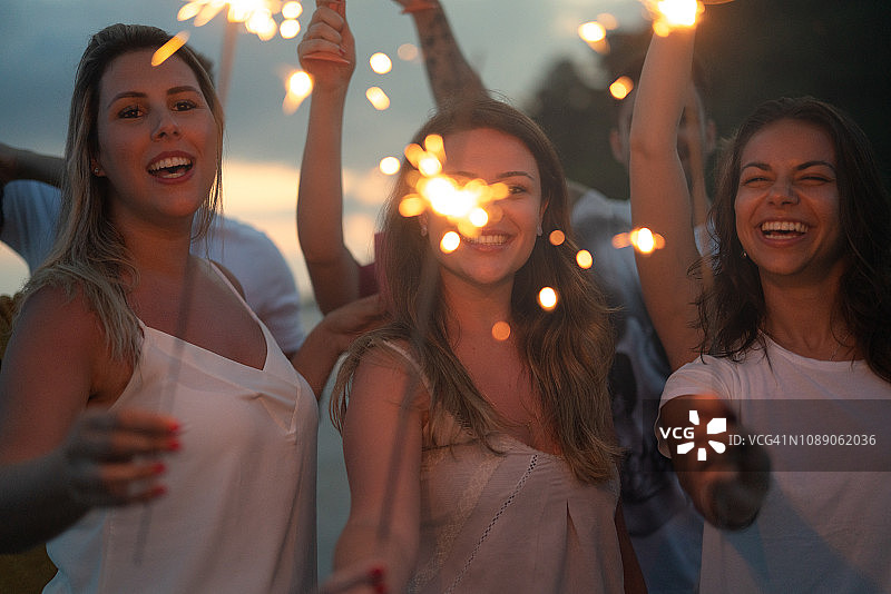朋友们在海滩上用烟花庆祝新年图片素材