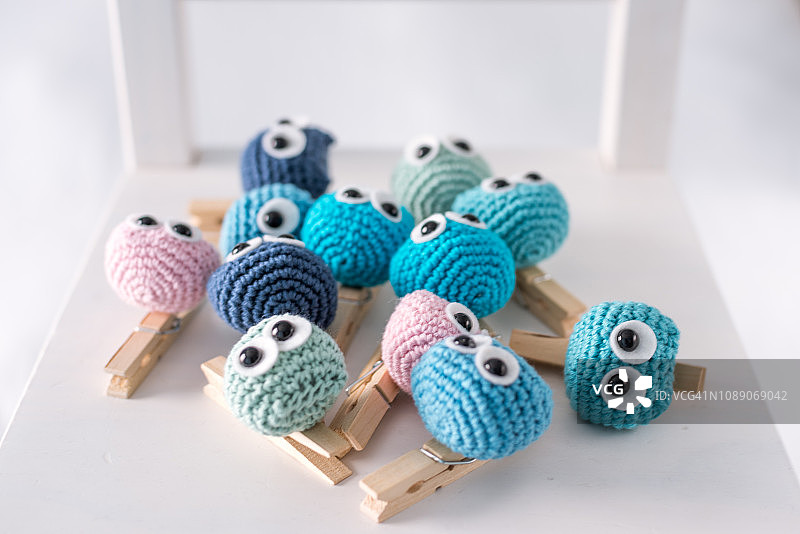 白色椅子上钩编的许多有趣的小猫头鹰（手工制作）图片素材