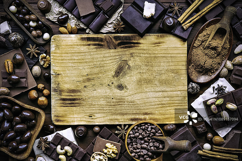 老式什锦巧克力、坚果和水果干，配砧板和绘图板图片素材