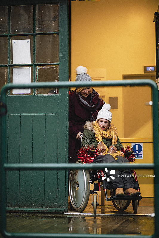 母亲用轮椅推着女儿图片素材