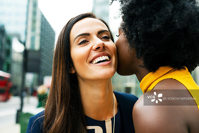 两个女人亲吻脸颊互相问候图片素材