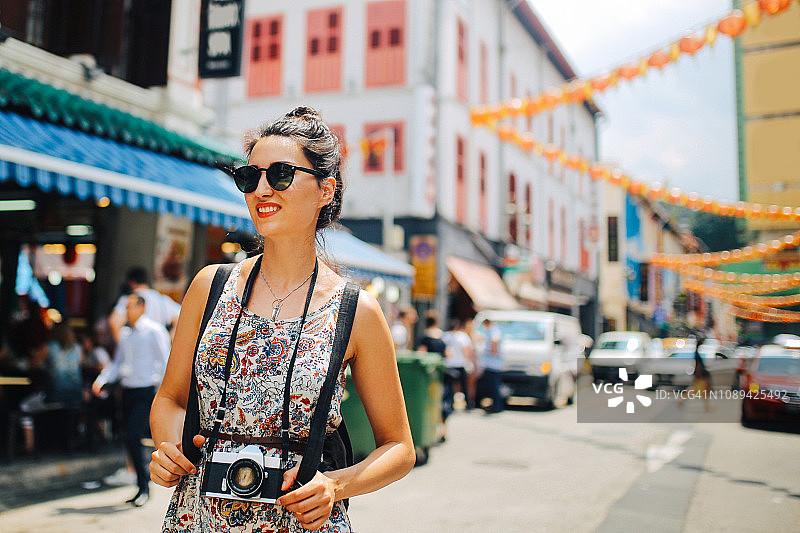 在新加坡唐人街街道上行走的时尚单身旅行女性图片素材