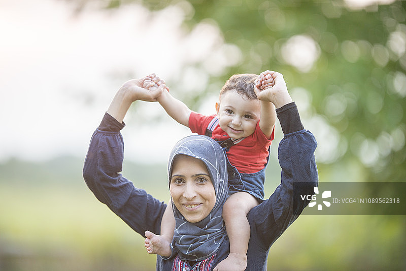 骑在妈妈的肩膀上图片素材