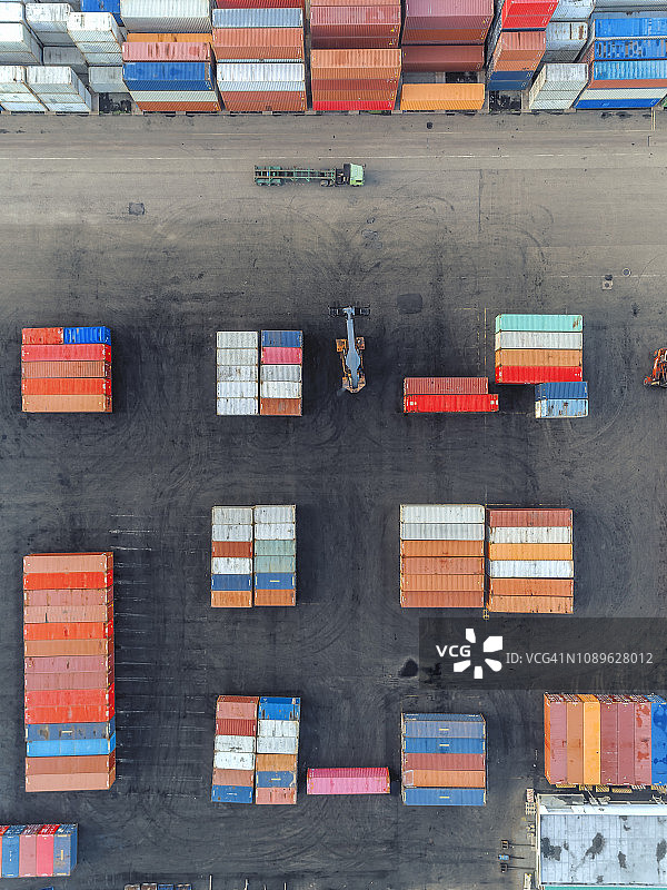 起重卡车在仓库中吊装集装箱的航拍俯视图图片素材