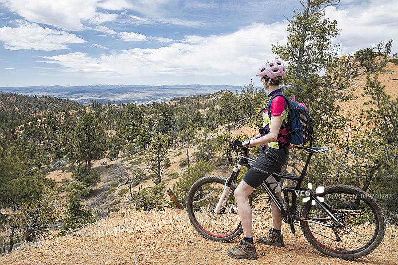犹他州峡谷观景点的女性山地自行车骑行者图片素材