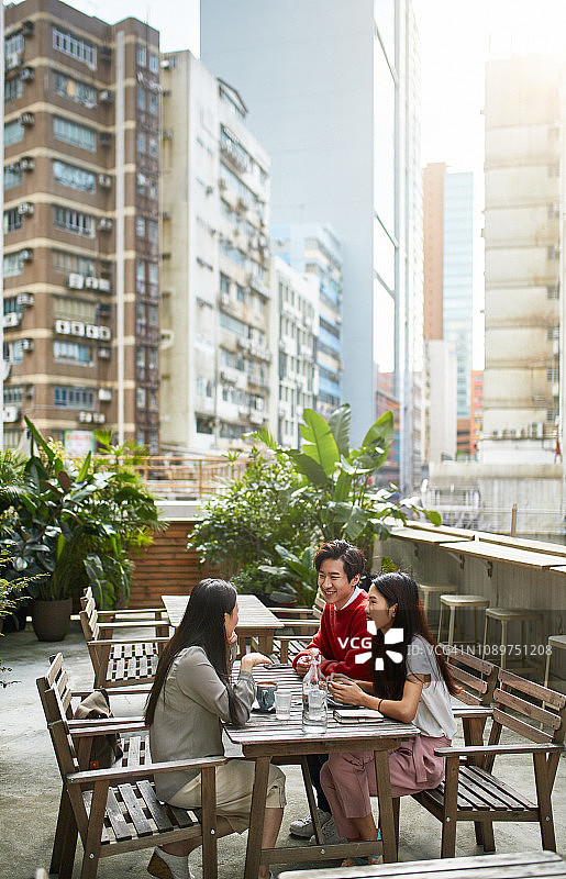 中国朋友在城市咖啡馆的桌旁交谈图片素材