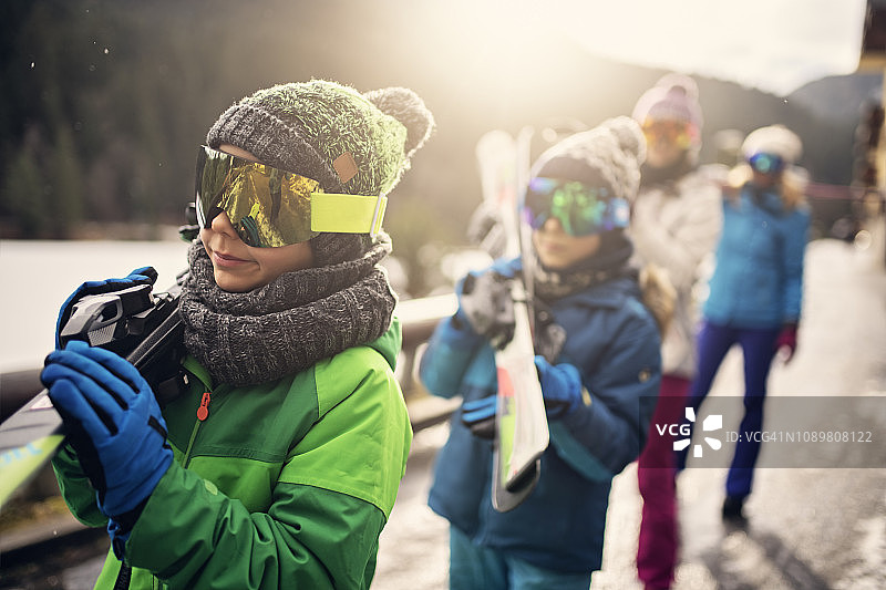 阳光明媚的冬日，一家人滑雪散步图片素材