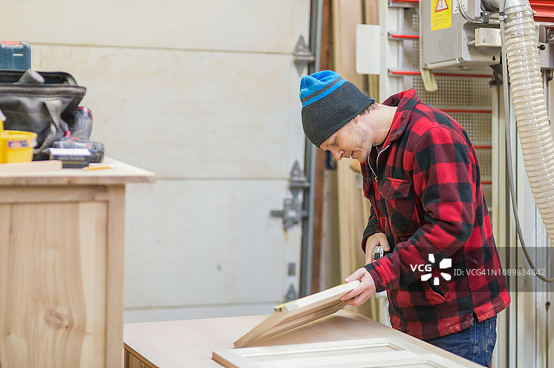中年男子在木工店制作橱柜图片素材