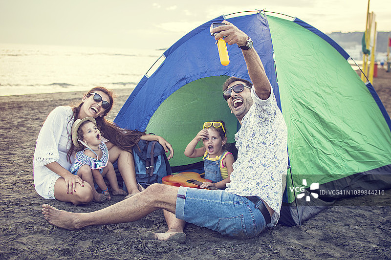 父母和女儿在海滩上弹吉他图片素材