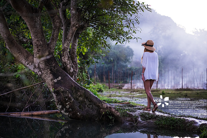 老挝稻田里的白色连衣裙年轻女人图片素材