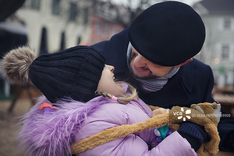 父亲和孩子（6-7岁）在冬天户外一起玩耍欢笑图片素材