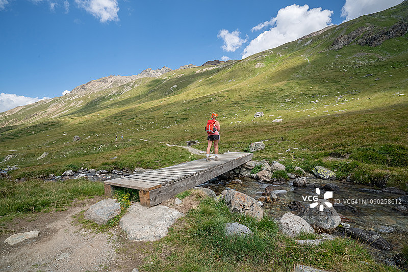 在山间小路上徒步的年轻女人图片素材