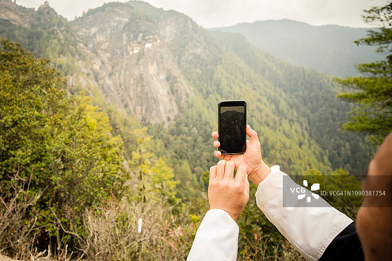 在不丹虎穴寺用手机拍照的男人图片素材