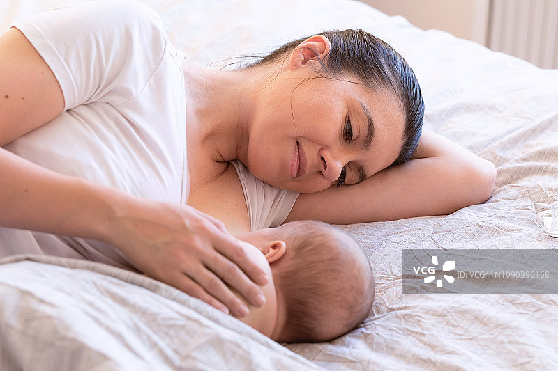 母亲哺乳特写，拥抱新生儿。母乳喂养婴儿，新生儿哺乳概念。宝宝睡前吃奶，母亲用母乳喂养儿子图片素材