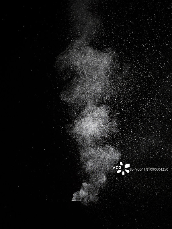 白色粉末粒子云在黑色背景上的冲击爆炸图片素材