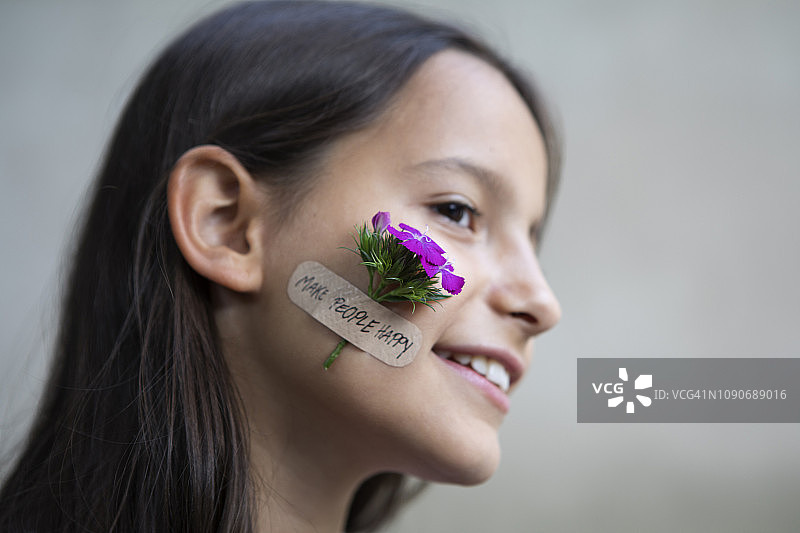 微笑的女孩脸颊上画着花朵图片素材