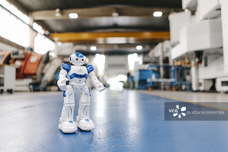 站在工厂车间地板上的玩具机器人图片素材
