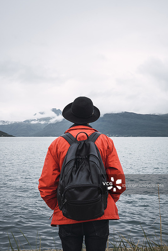 站在水边眺望远方的年轻人（背影）图片素材