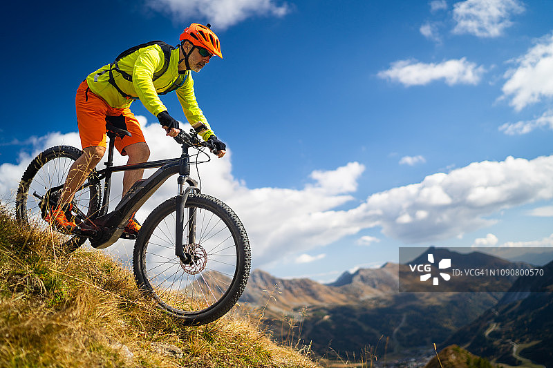 46岁健壮男子骑电动山地车在奥地利山区骑行图片素材